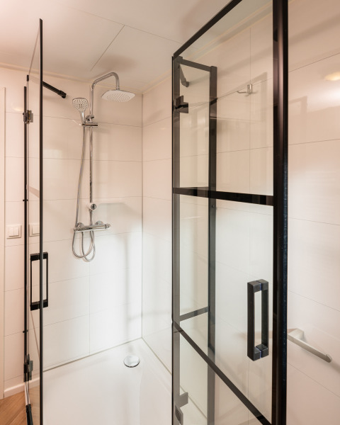 Moderne Duschkabine mit Glastüren und Regendusche in der Wellness Boutique, Holiday Park Mölke, Niederlande.