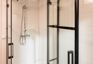 Cabina de ducha moderna con puertas de vidrio y ducha tipo lluvia en Wellness Boutique, Holiday Park Mölke, Países Bajos.