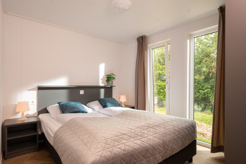 Helles Schlafzimmer mit Doppelbett, Fenster zum Garten, im Wellness Boutique Holiday Park Mölke, Niederlande.