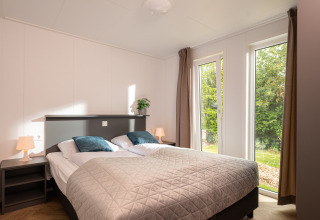 Chambre moderne avec grand lit et vue sur jardin, Wellness Boutique au Holiday Park Mölke, Pays-Bas.