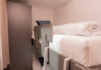 Moderne stapelbedden en een kleerkast in een kleine kamer bij Wellness Boutique, Holiday Park Mölke, Nederland.