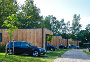 Gruppenunterkunft mit Hot Tub (7x Happy Oak Lodge) und parkenden Autos im Holiday Park Mölke, Niederlande.