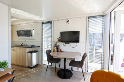 Interior moderno de salón y cocina americana en la casa flotante 'De Hoop' en Marina Parcs - Jachthaven De Hoop, Países Bajos.