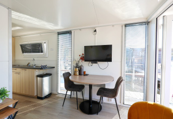 Interior moderno de salón y cocina americana en la casa flotante 'De Hoop' en Marina Parcs - Jachthaven De Hoop, Países Bajos.