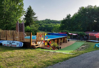 Udendørs swimmingpool og afslapningsområde på Camping La Perle i Nouvelle-Aquitaine, Frankrig.