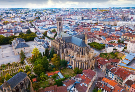Luftfoto af en historisk katedral og omkringliggende byhuse i Saint-Médard-la-Rochette i Nouvelle-Aquitaine, Frankrig.