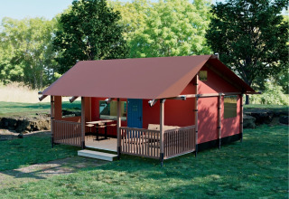 Wander Lodge bij Holiday park De Boshoek in Nederland, met een veranda en groene zomeromgeving.