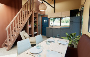 Modern lodge-interieur met keuken, eettafel en trap in Wander Lodge, vakantiepark De Boshoek, Nederland.