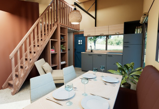 Modern lodge-interieur met eetruimte, keuken en trap in Wander Lodge, De Boshoek, Nederland.
