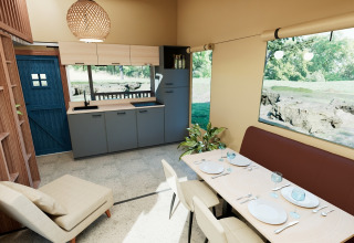 Modern lodge-interieur met eetgedeelte, keuken en grote ramen in Wander Lodge, De Boshoek, Nederland.