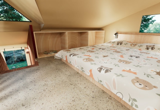 Soveværelse i Wander Lodge på Holiday park De Boshoek, med lavt loft og barnligt sengetøj.