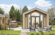 Moderne Tiny Lodge med udendørs boblebad og terrasse ved Veluwepark de Bosgraaf i Holland om foråret.