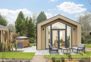 Modern Tiny Lodge with outdoor hot tub and patio at Veluwepark de Bosgraaf in the Netherlands in spring.