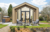 Tiny Lodge met hot tub op Veluwepark de Bosgraaf in Nederland, modern tiny house met terras en zithoek.