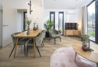 Gemütliches Wohn- und Esszimmer in der Tiny Lodge mit Whirlpool im Veluwepark de Bosgraaf, Niederlande.