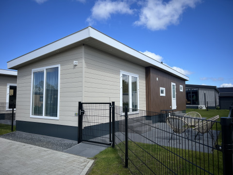 Chalet moderno Sea bass en Vakantiepark de Zeeuwse Parel, Países Bajos, con terraza y patio cercado visibles.