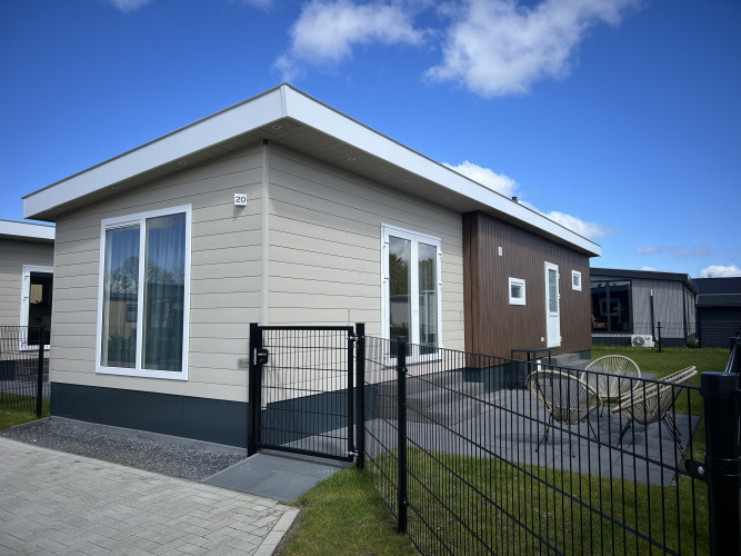 Chalet moderno Sea bass en Vakantiepark de Zeeuwse Parel, Países Bajos, con terraza y patio cercado visibles.