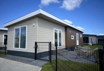 Modern chalet Sea bass bij Vakantiepark de Zeeuwse Parel in Nederland, met omheinde tuin en terras in beeld.