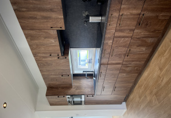 Moderne keuken met houten kasten in Sea bass chalet, Vakantiepark de Zeeuwse Parel, Nederland.