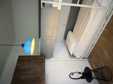 Modern chalet room with a bunk bed, blue lamp, wardrobe, and wood floor at Vakantiepark de Zeeuwse Parel.