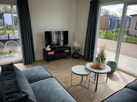 Helles Wohnzimmer im Chalet Sea bass im Vakantiepark de Zeeuwse Parel, Niederlande, mit moderner Einrichtung.