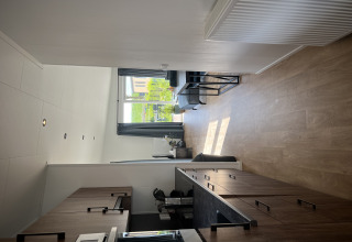 Interior moderno de chalet con cocina y sala en Sea bass, Vakantiepark de Zeeuwse Parel, Países Bajos.