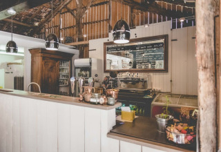 Rustieke bar van Club Les Ormes vakantiepark in Nouvelle-Aquitaine, Frankrijk, met houten barmeubel.