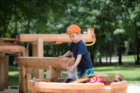 Kind speelt aan een waterstructuur bij Club Les Ormes, vakantiepark in Nouvelle-Aquitaine, Frankrijk.