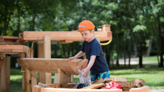 Dreng leger med vandkonstruktion på legeplads i Club Les Ormes, feriepark i Nouvelle-Aquitaine, Frankrig.