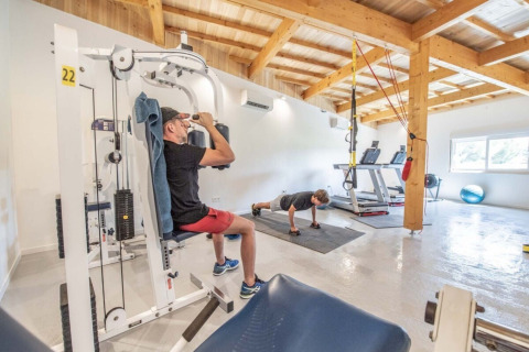 To personer træner i et lyst fitnesscenter på Club Les Ormes feriepark i Nouvelle-Aquitaine, Frankrig.