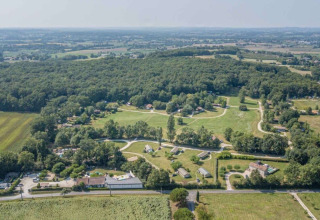 Luftfoto af Club Les Ormes feriepark ligger i det frodige landskab i Nouvelle-Aquitaine, Frankrig.