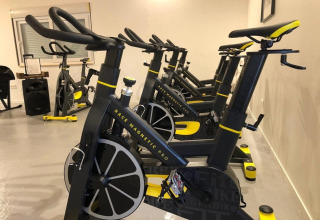 Cyclette da palestra allineate nella sala fitness al Club Les Ormes, Nouvelle-Aquitaine, Francia.