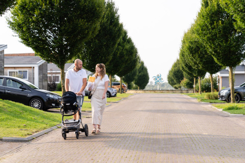 Koppel wandelt met kinderwagen aan Berg Lodge - Sauna, Resort Mooi Bemelen, Nederland.