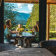 Familie nyder en frokost på Panorama Lodge ved Pressegger See i Østrig med udsigt over bjerge og natur.