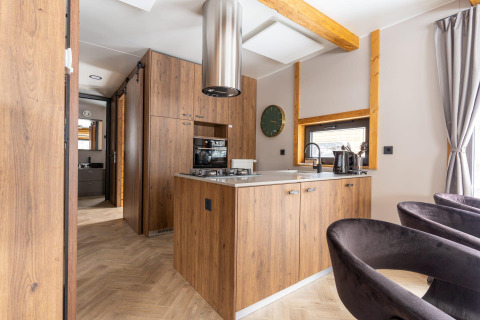 Cuisine moderne en bois avec îlot central à la Panorama Lodge au Pressegger See, Autriche, éclairée naturellement.
