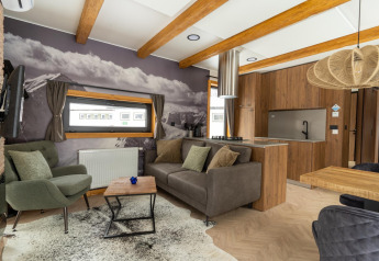Soggiorno moderno nella Panorama Lodge con murale di montagna, travi a vista e cucina a pianta aperta.