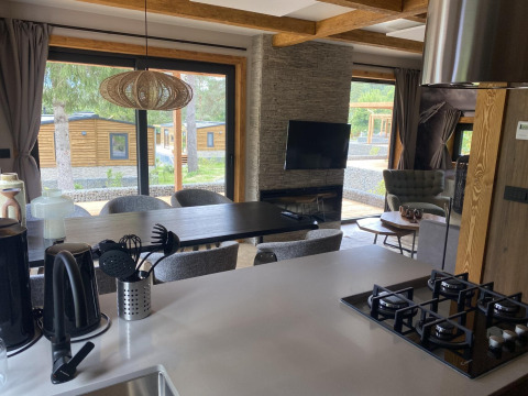 Cocina moderna y sala de estar en Panorama Lodge, Pressegger See, Austria, con gran vista a través de las ventanas.