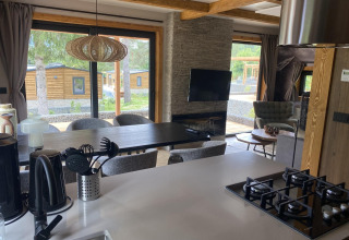 Cocina moderna y sala de estar en Panorama Lodge, Pressegger See, Austria, con gran vista a través de las ventanas.