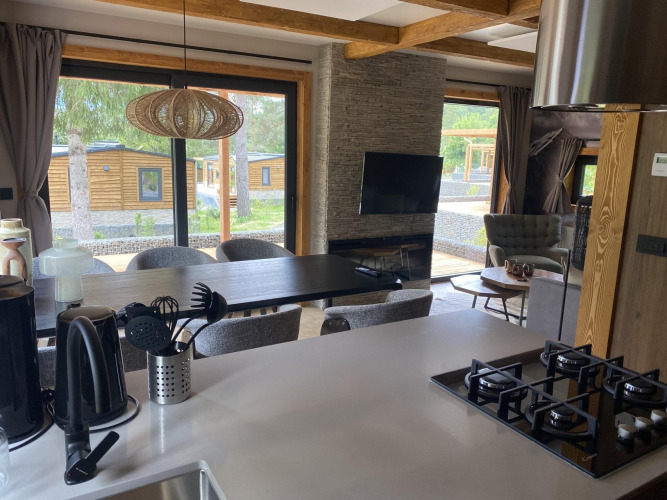 Modern kitchen and living area at Panorama Lodge, Pressegger See, Austria, with large window view outside.