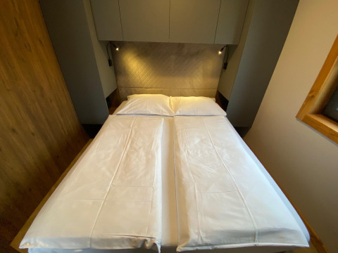 Et værelse på Panorama Lodge ved Pressegger See i Østrig med to enkeltsenge skubbet sammen og moderne indretning.