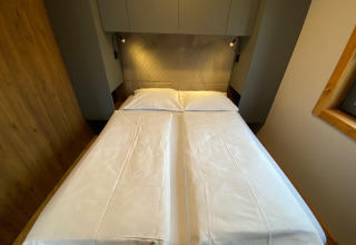 Chambre au Panorama Lodge au Pressegger See en Autriche avec deux lits simples rapprochés et une décoration moderne.