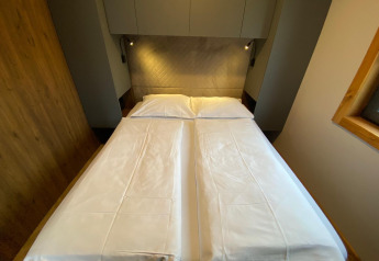 Et værelse på Panorama Lodge ved Pressegger See i Østrig med to enkeltsenge skubbet sammen og moderne indretning.