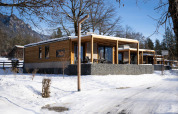 Panorama Lodge cabins set in a snowy winter landscape, with mountain views and clear blue sky visible.