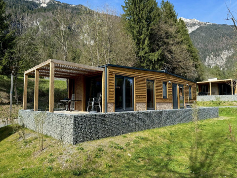 Panorama Lodge bij de Pressegger See in Oostenrijk, moderne houten lodge met terras en bergzicht.