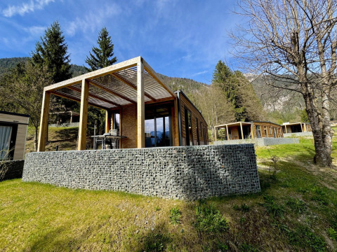 Moderne Panorama Lodge bij Pressegger See in Oostenrijk met houten terras en uitzicht op de bergen.