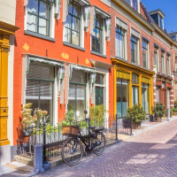 Maisons en rangée colorées avec vélo dans une rue ensoleillée de Jubbega, Friesland, aux Pays-Bas.