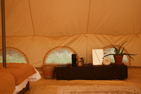 Interior de la tienda safari Bell Tent Emperor en REBL Outdoor, Países Bajos, con decoración acogedora.