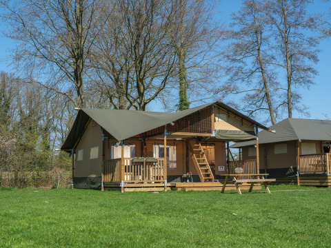 Tente safari Ranger Lodge avec véranda au parc de loisirs Den Blanken, Pays-Bas, sous ciel bleu.