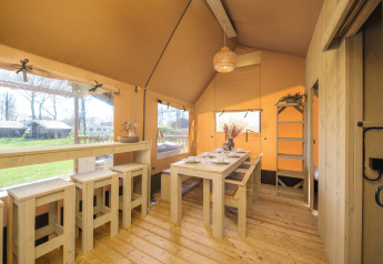 Interieur van de Ranger Lodge safaritent met houten meubels bij Recreatiepark Den Blanken, Nederland