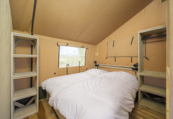 Schlafzimmer im Safari-Zelt Ranger Lodge mit Doppelbett und Regalen im Recreation Park Den Blanken.